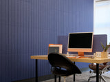 Modern office setup with a blue wall and a desk with a computer.