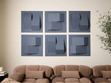 Six blue-gray tiles with dimensional geometric cutouts arranged in a 2x3 grid above a tan sectional sofa.