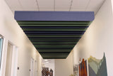 Ceiling acoustic panel in a hallway with white walls and a colorful mural.