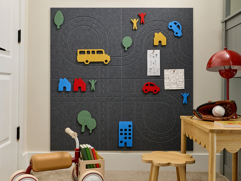 Children's playroom with a felt pin board featuring colorful toy figures and vehicles.