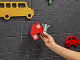 Hand interacting with toy cars on a felt play mat with road patterns