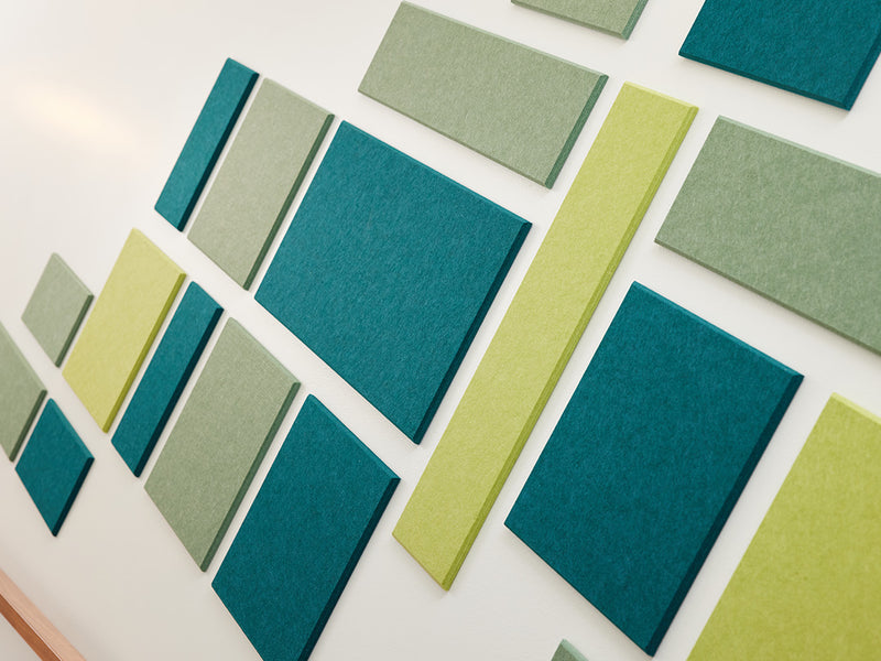A Felt Right wall art design in shades of blue and green  creating a geometric shape on a wall 