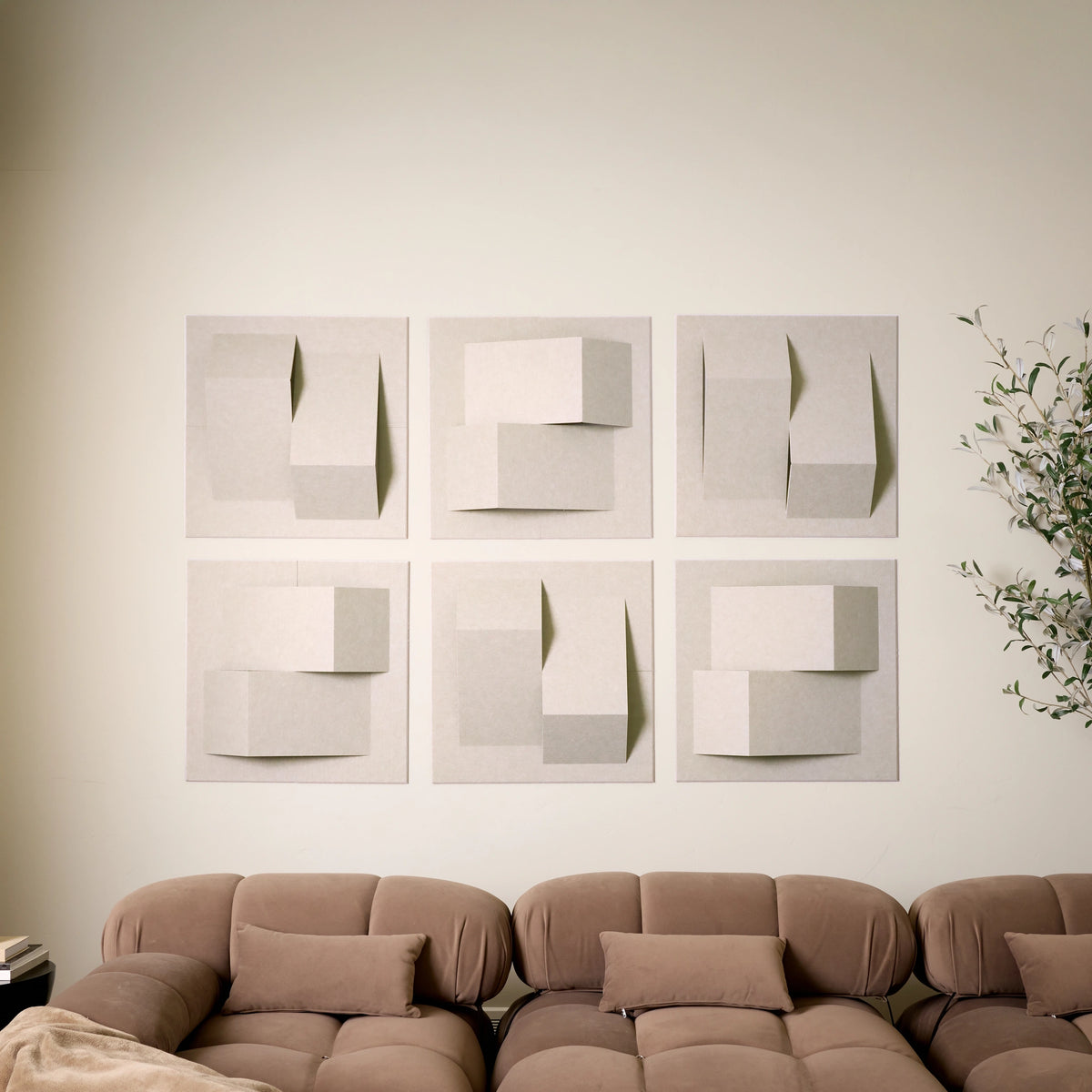 Cream acoustic felt tiles with 3D design creating peaks above a brown couch