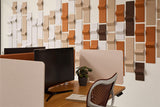 Modern office setup with a textured wall panel design and desk dividers.