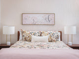A Felt Right wall art design of river tiles in a cream shade covering a wall in a bedroom with a bed and some wall art.