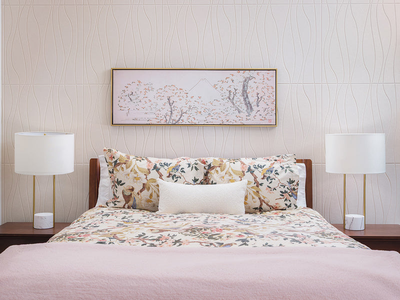 A Felt Right wall art design of river tiles in a cream shade covering a wall in a bedroom with a bed and some wall art.