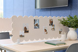 Scalloped office divider with photos on a desk in an office setting