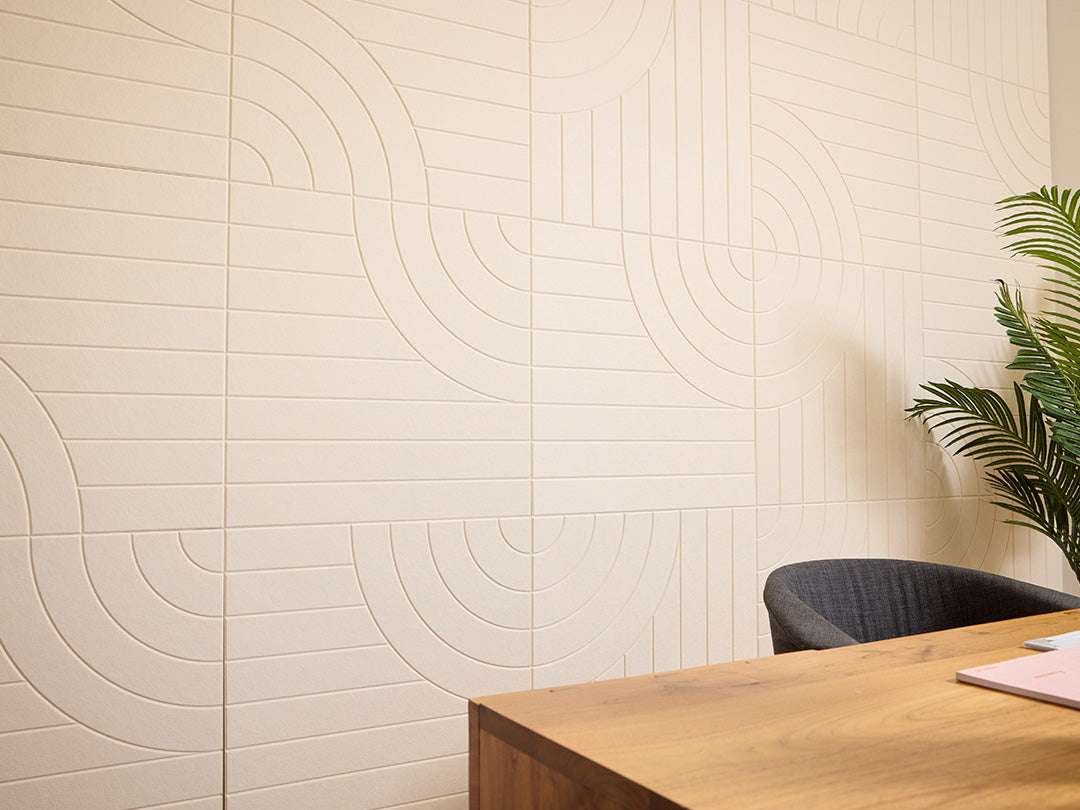 Beige wall with circular pattern next to a wooden desk and chair