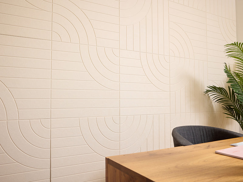 Beige wall with circular pattern next to a wooden desk and chair