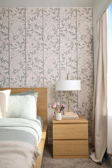 Bedroom with floral wallpaper, wooden nightstand, and lamp.