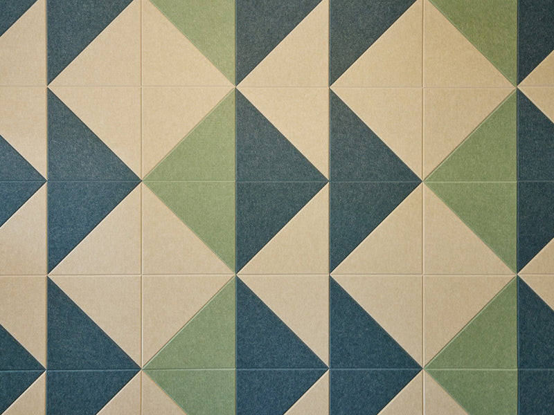 A Felt Right wall art design in shades of green and cream triangles tiles covering a wall.