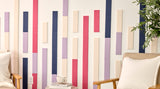 Two beige armchairs in a room with a decorative wall featuring vertical color acoustic tiles.