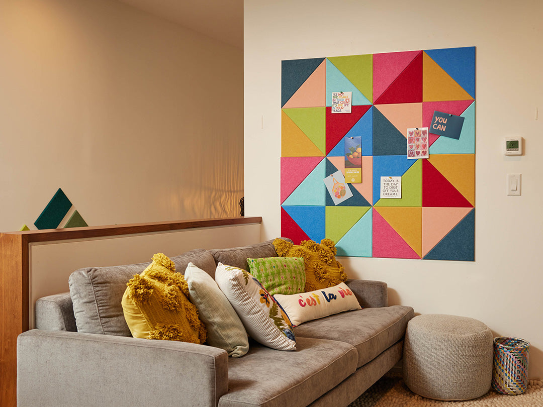 Woman and child in a living room with a colorful geometric wall art piece.