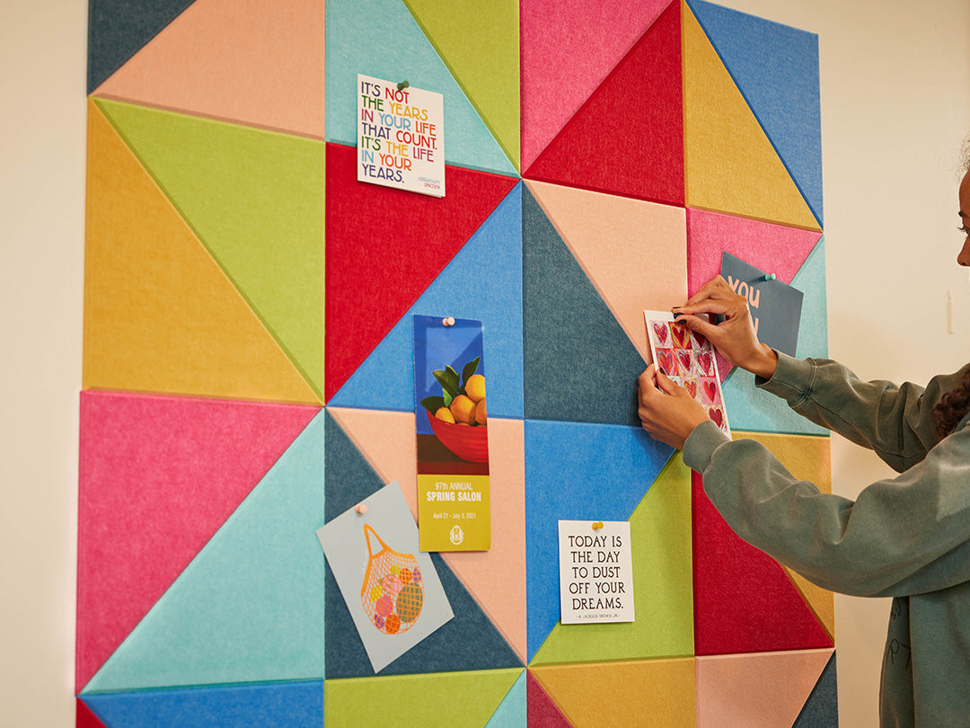 Woman and child in a living room with a colorful geometric wall art piece.