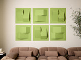 Six green dimensional wall tiles with geometric cutout patterns arranged in a 2x3 grid above a brown sofa.