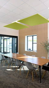 Two lime green square acoustic panels suspended from white ceiling grid in modern office conference room.