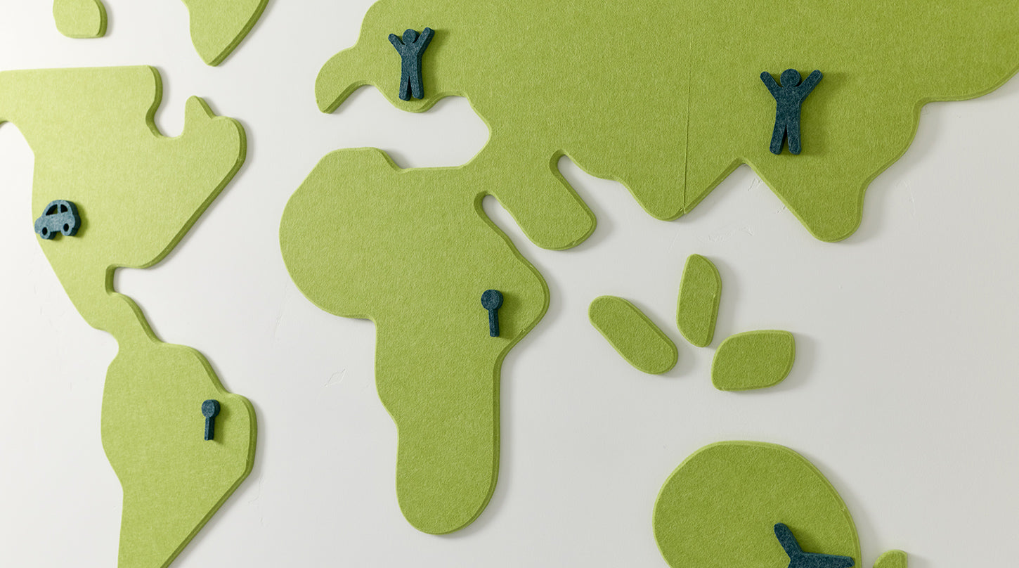 Green acoustic felt cutout world map with small figures on a white background