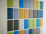 Felt Right wall art using green, cream, blue, and yellow felt rectangle tiles on a white wall.