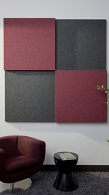 Four fabric-covered acoustic panels in burgundy and charcoal arranged in a 2x2 grid on a wall.