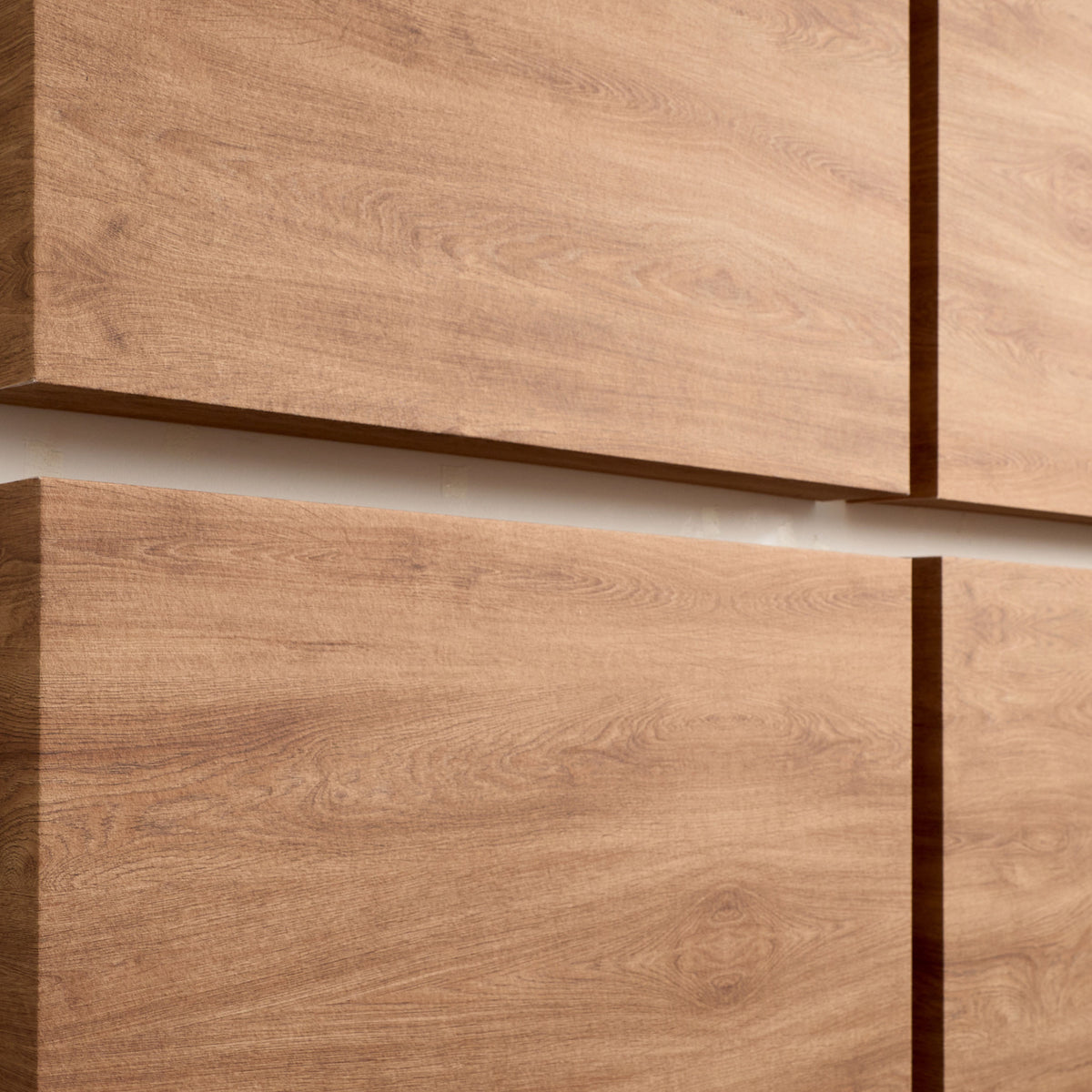 Close-up of four wood-look panel surfaces arranged in a grid, showing warm medium-brown grain textures and thin dark edge lines.