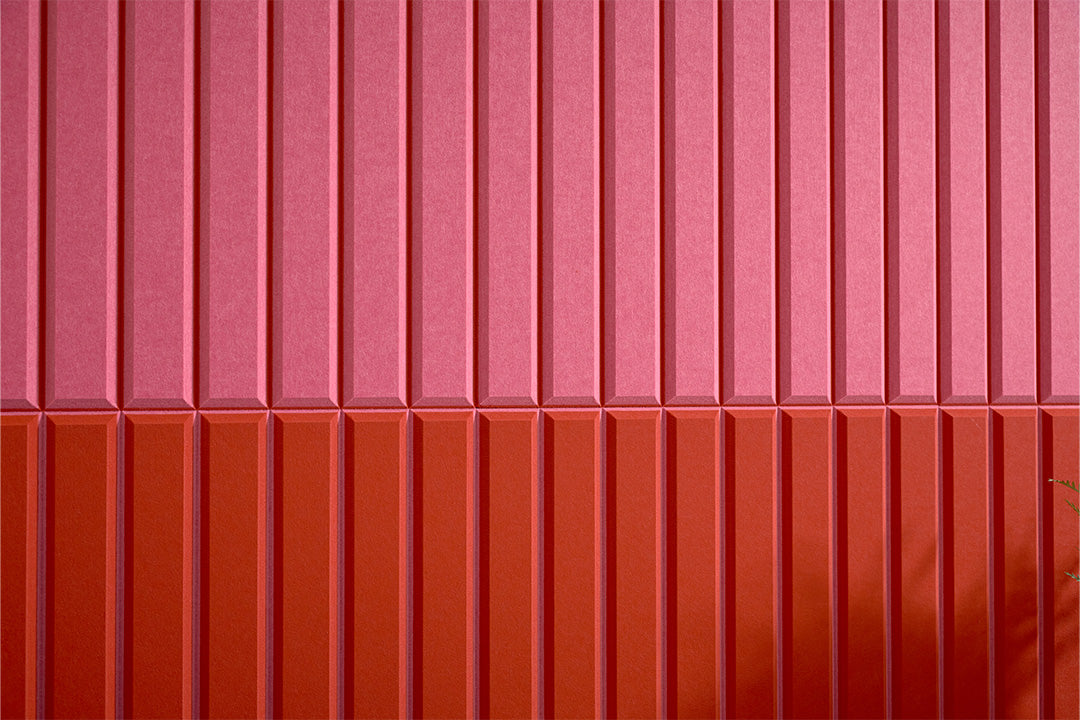 Colorful acoustic wall panel alternating pink and red stripes