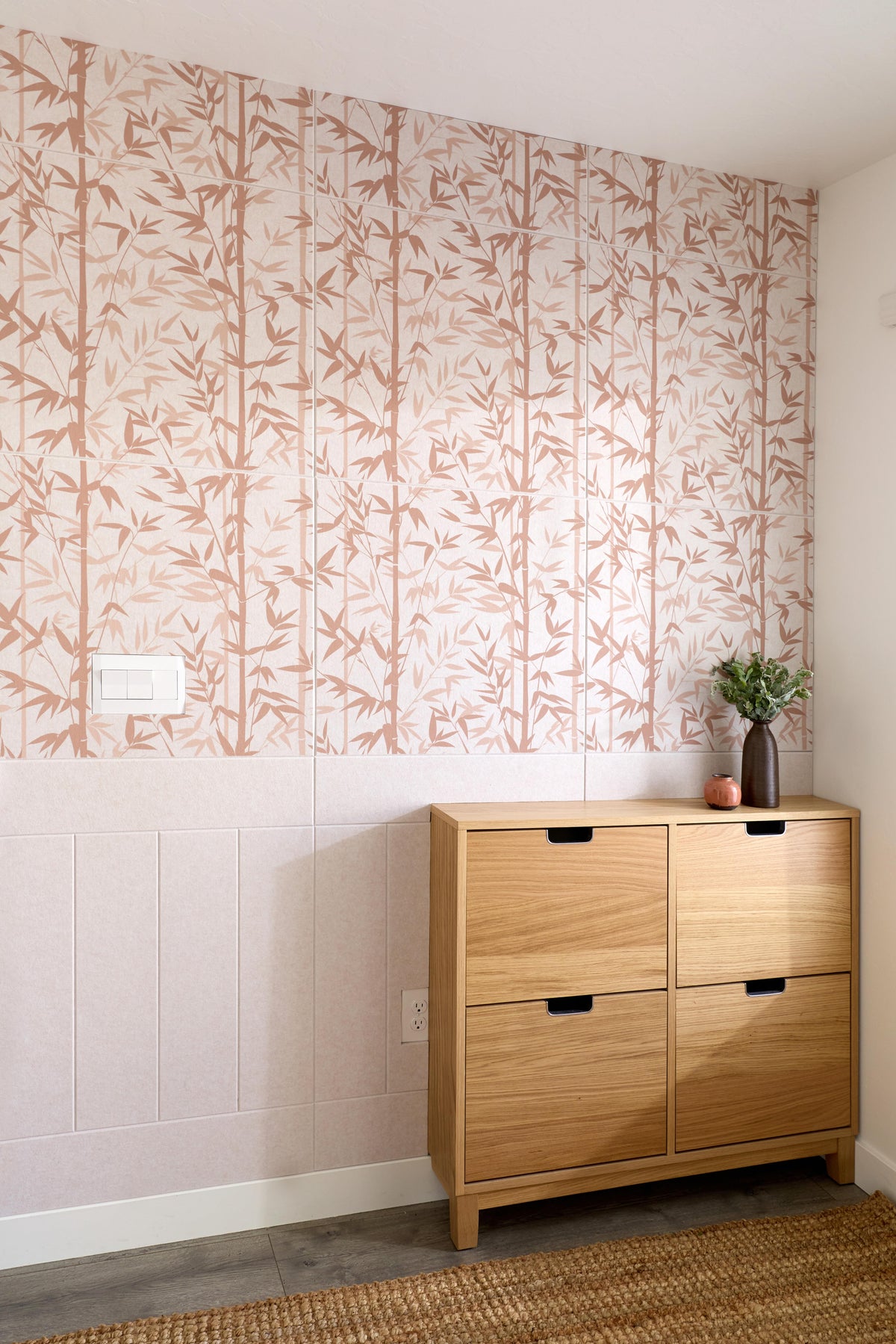 Wooden shoe cabinet against a wall with abstract patterned wallpaper