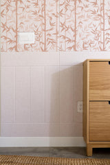 Bathroom corner with floral-patterned tile wall and wooden cabinet.