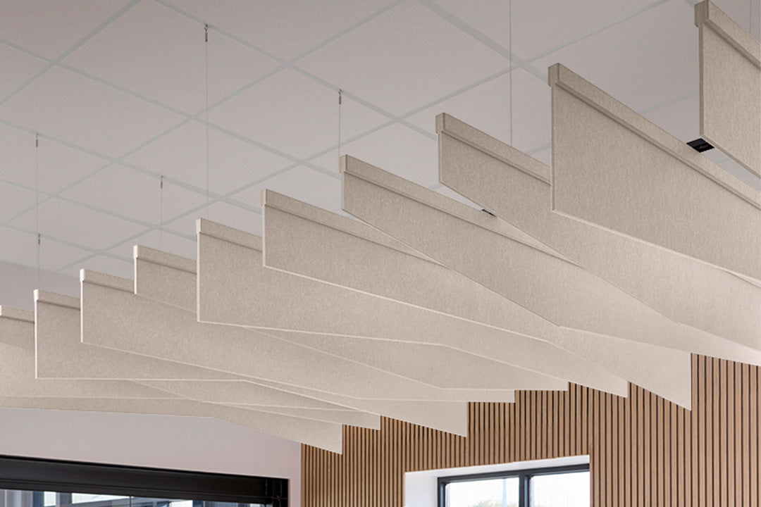Modern ceiling acoustic blades with geometric design in a room with wooden paneling.