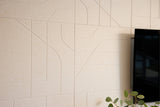 Beige acoustic wall panels with a television and plant in the corner