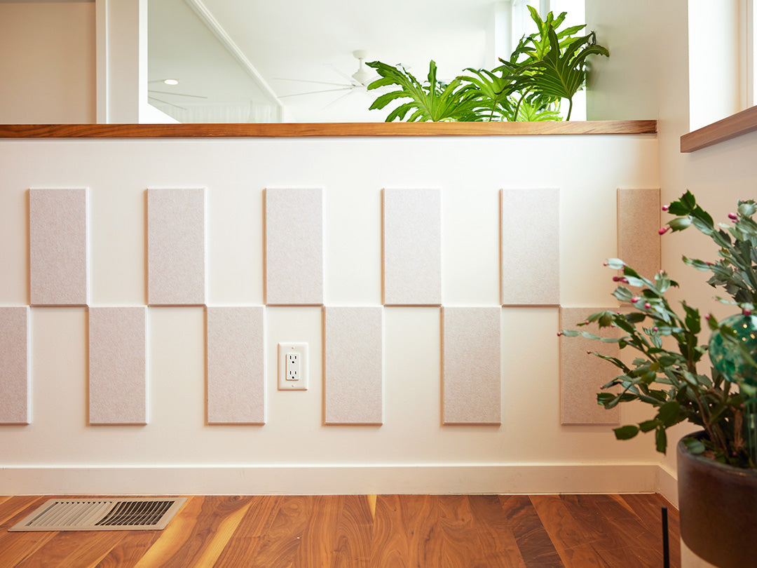 Felt Right wall art design using cream felt tiles and negative space to create a pattern going around the wall and a woman leaning on it