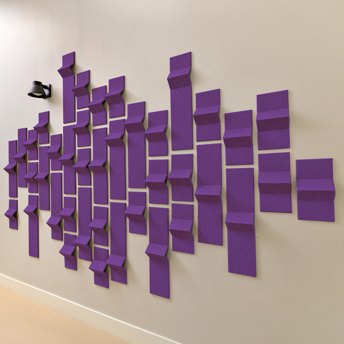 Purple acoustic felt tiles with peak dimensions on a wall