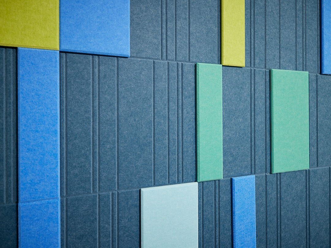 A Felt Right wall art design in shades of blue and green creating a geometric design covering a wall in a room