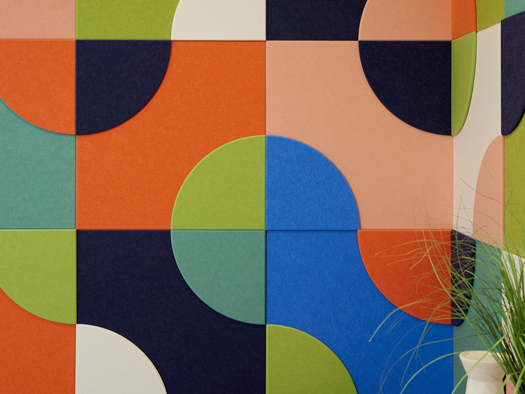 Colorful geometric patterned wall with a plant in the corner