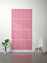 Pink felt sheet with white parallel vertical line engraving pattern displayed on wall.