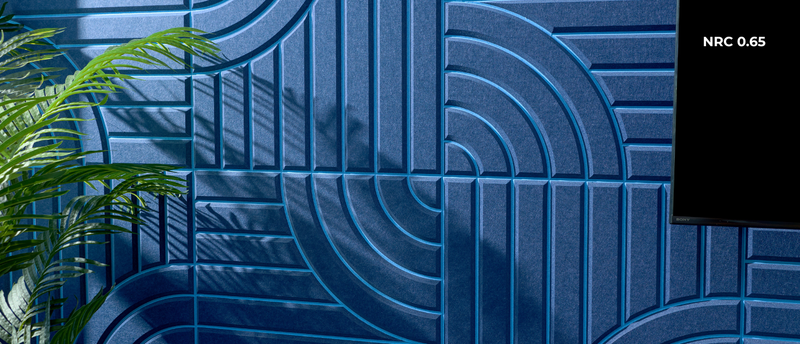 Blue textured wall with geometric patterns and a plant on the left side.