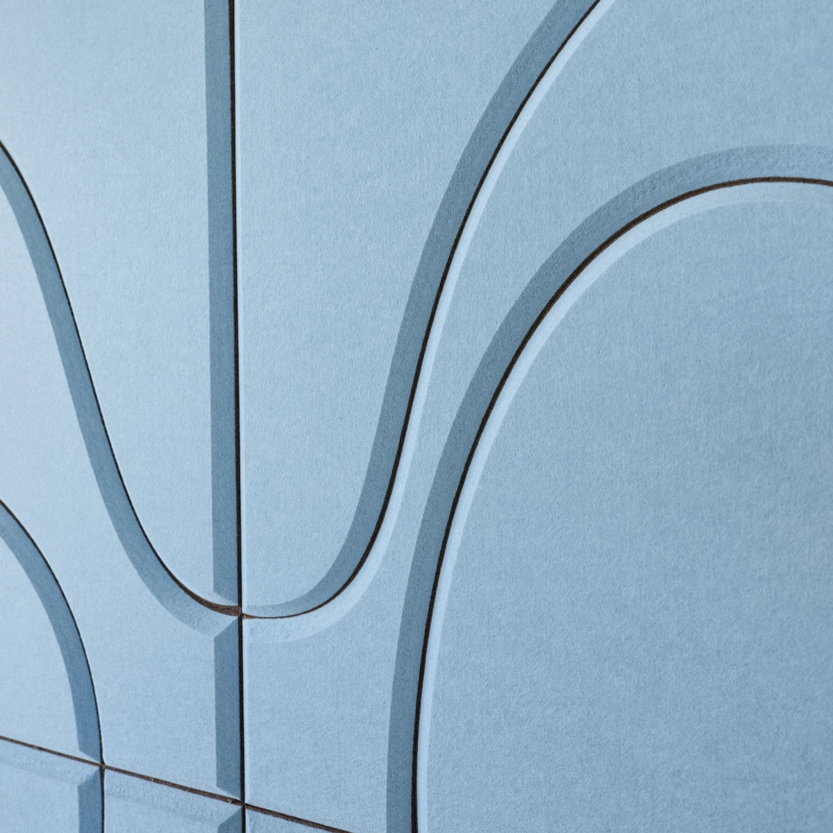 A close-up of a light blue textured surface with curved dark gray contour lines forming an abstract geometric pattern.