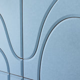 A close-up of a light blue textured surface with curved dark gray contour lines forming an abstract geometric pattern.