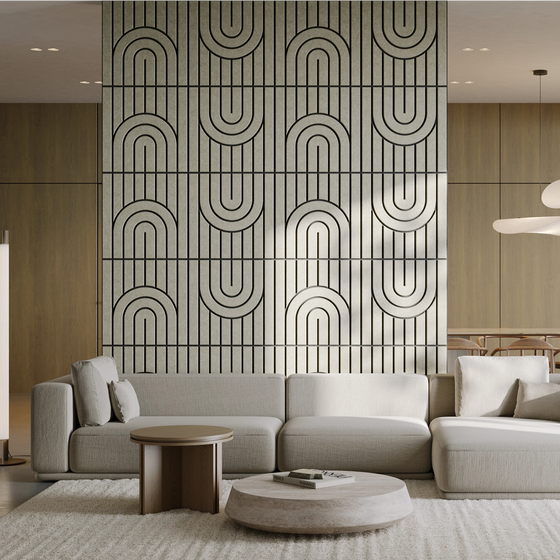 A modern living room featuring a large geometric wall panel with a repeating black arch pattern on a light background, styled behind a light gray sectional sofa and round coffee tables.