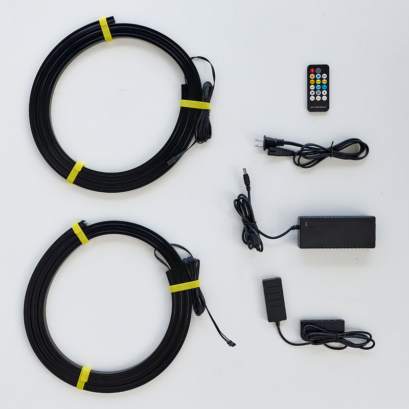 Black coiled cable kit with two large loops secured by yellow bands, shown with a remote control, power adapter, and small push-button controller on a white background.