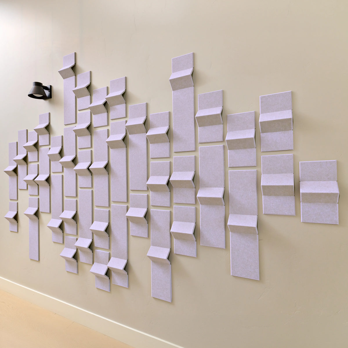 Light purple felt tiles on a wall with peak points to help with acoustics