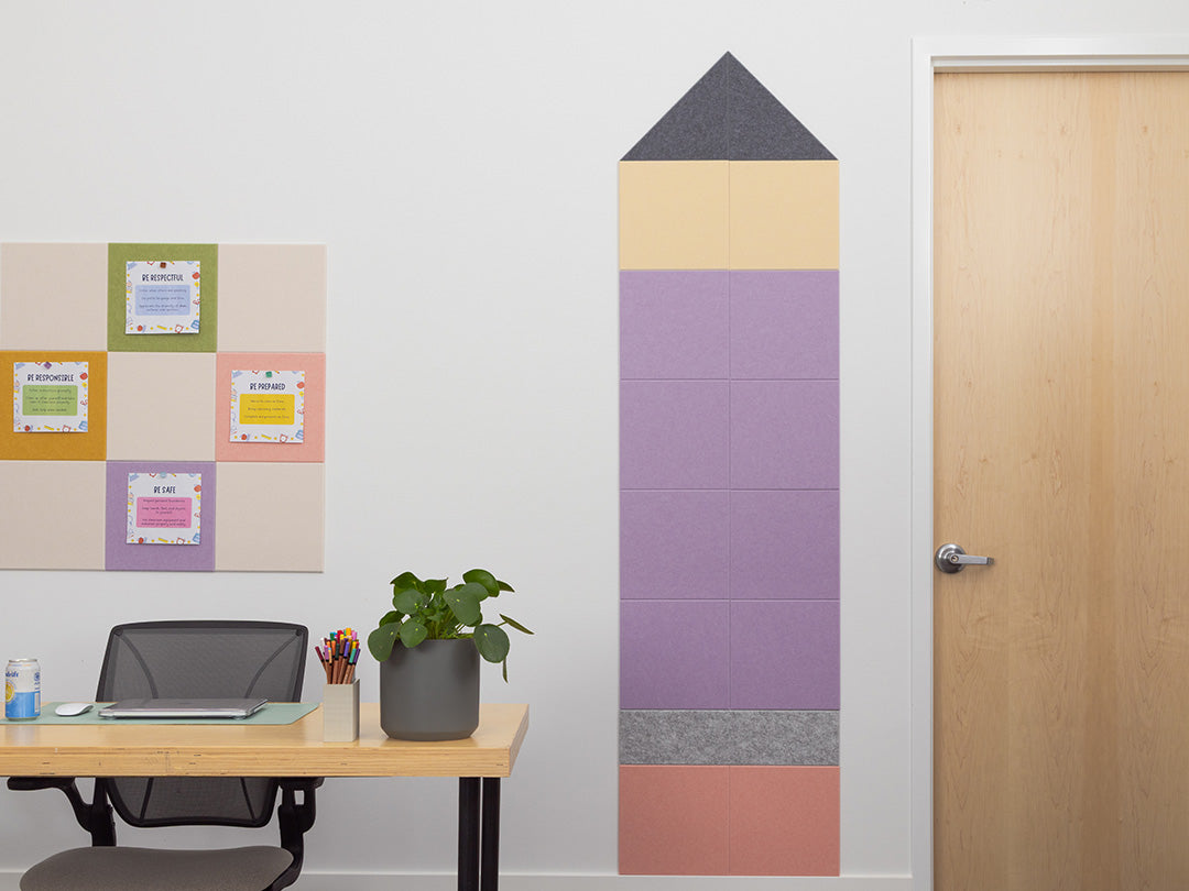 Decorative wall panel shaped like a pencil in an office setting with a desk and door.