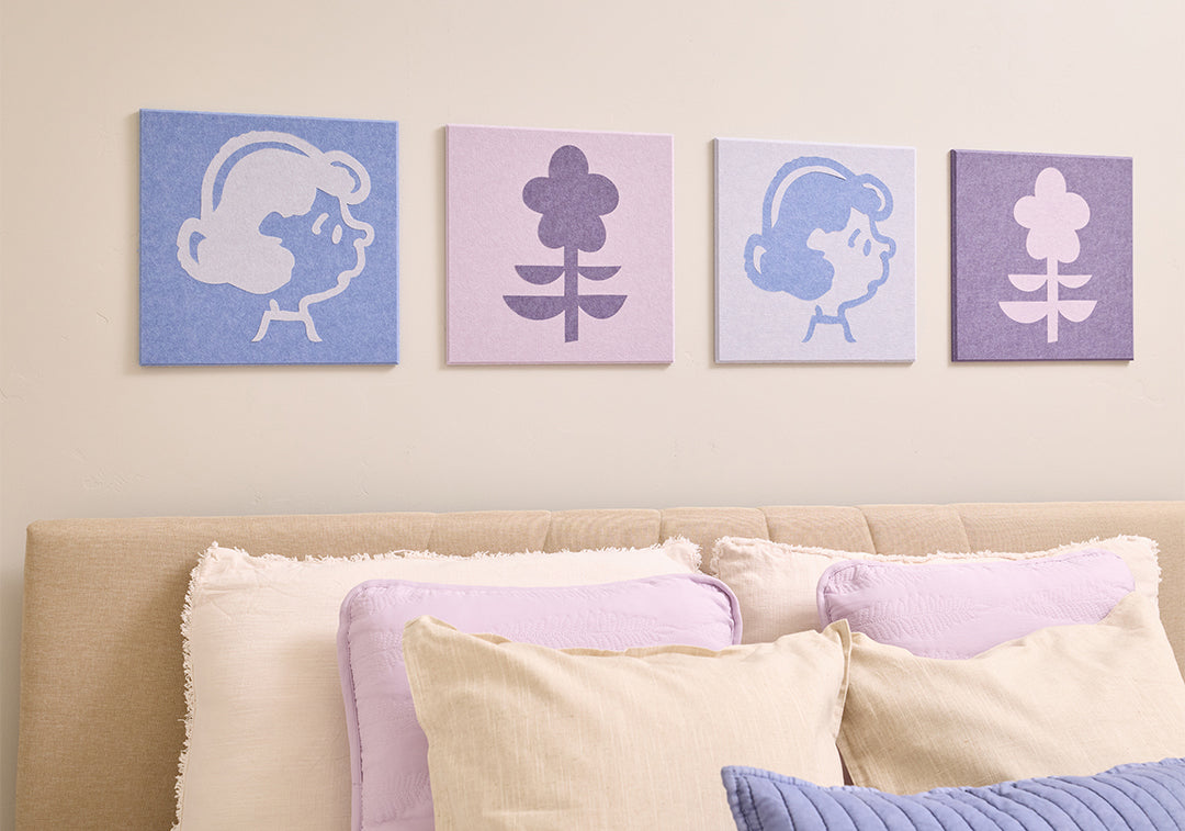 Bedroom with Peanuts Lucy wall art above a bed with a plush toy.