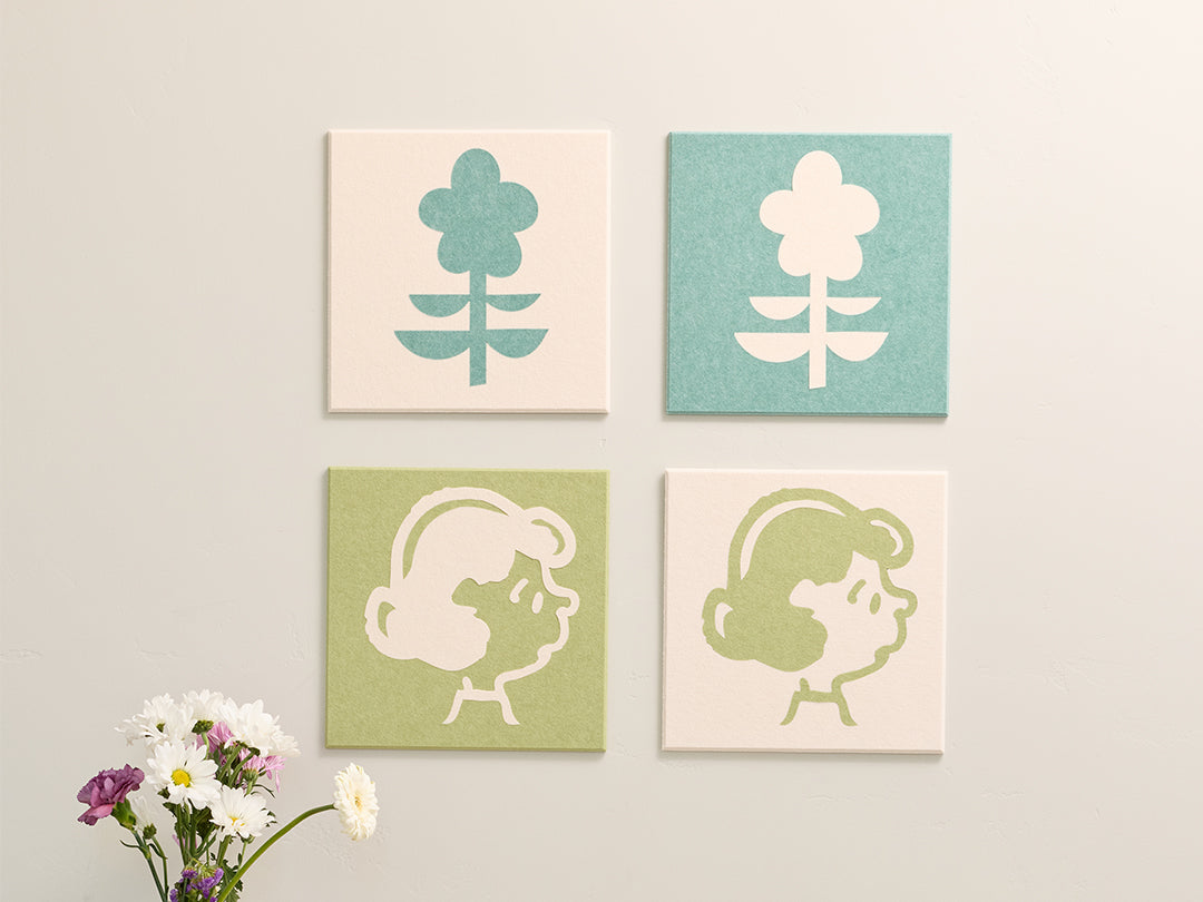 Four square wall art pieces with floral and abstract designs on a white wall.