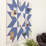 Geometric patterned wall art with pinned photos and a plant in the foreground