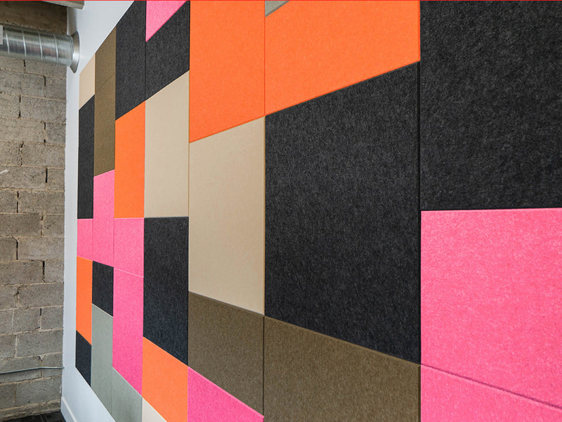 Geometric patterned wall with colorful tiles on a building exterior.