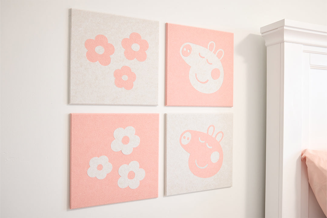 Four pink and white wall art pieces on a light gray wall.