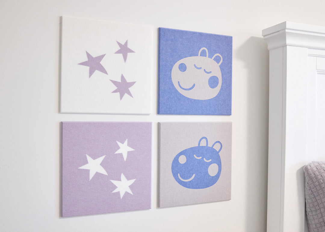 Four framed illustrations of stars and a sheep on a white wall.