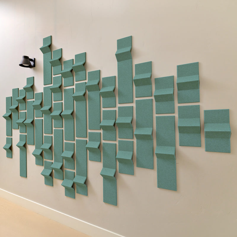 Soft green felt acoustic tiles on a wall with a 3D design 