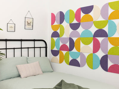 Bedroom with a colorful geometric wall design and black metal bed frame.