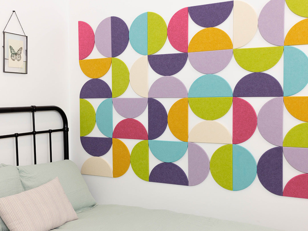 Bedroom with a colorful geometric wall design and black metal bed frame.